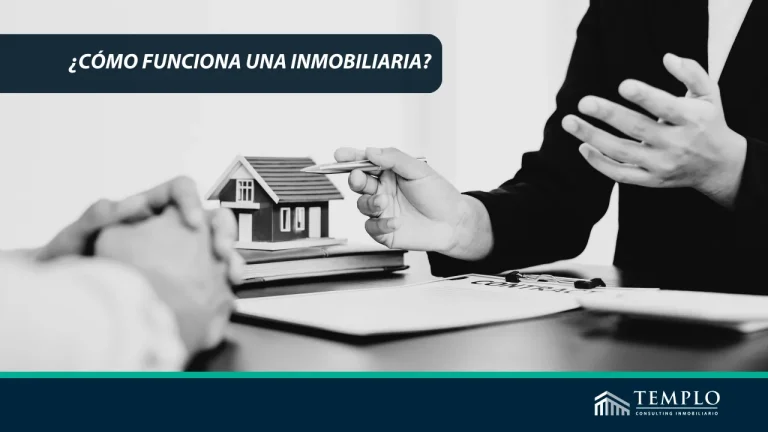 Oficina de una inmobiliaria con agentes trabajando y discutiendo en una mesa de reuniones.
